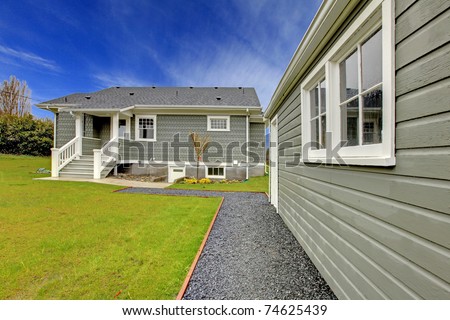 Small cute grey New England style home with matching detached garage.