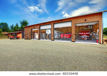Large ranch garage with car, truck, boat and trailer in red colors. Washington, State. US