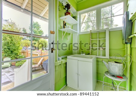 Fresh green mud room with windows and sink.
