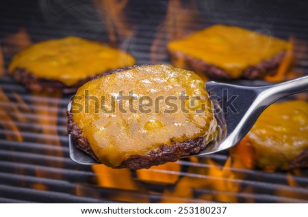 Delicious Juicy Cheeseburgers on a Flaming BBQ Grill