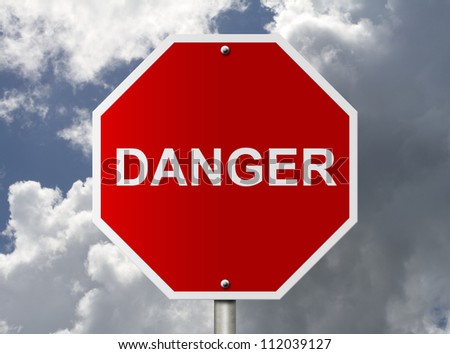 An American road stop sign with word Danger with clouds and sky, Stop it is dangerous