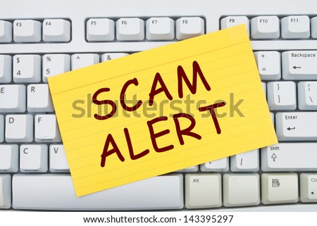 Computer keyboard keys with index card with words Scam Alert, Scam Alert