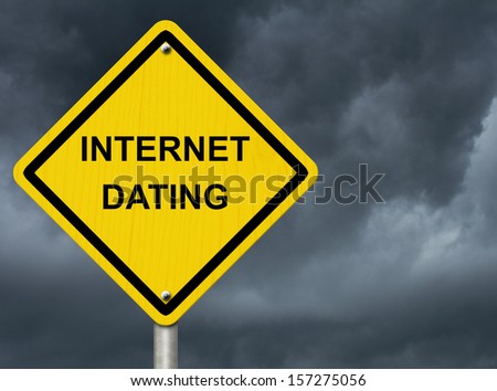 A road warning sign against a stormy sky with words Internet Dating, Warning about Internet Dating