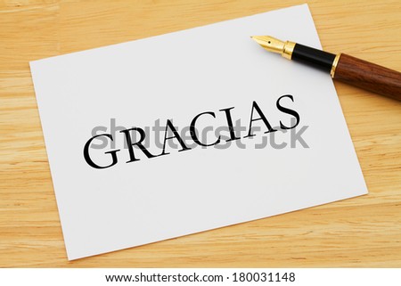 A white card with a fountain pen on a wooden desk, Writing a Thank You Note Gracias