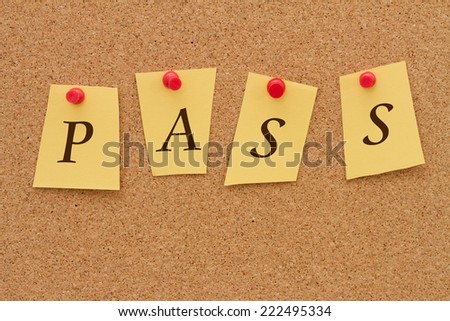 Getting a good grade, Four yellow notes on a cork board with the word Pass