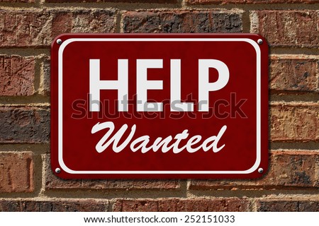 Help Wanted Sign,  A red sign with the word Help Wanted with an arrow on a brick wall