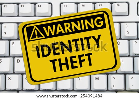 Identity Theft Warning Sign,  A yellow sign with the words Identity Theft on a keyboard
