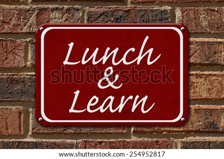 Lunch and Learn Sign,  A red sign with the word Lunch and Learn on a brick wall