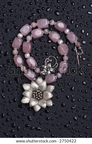 A bead necklace with clear stones on black background