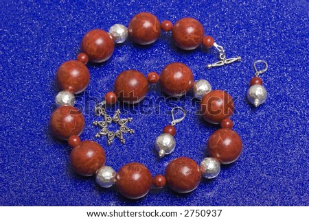 A bead necklace with red beads on a bright blue background