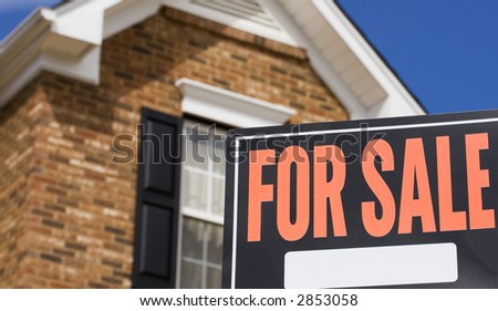 Home for sale - a sign in front of a brick house