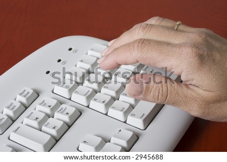 close-up of a computer white keyboard with woman typing on the numeric pad