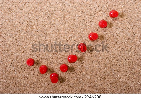 Red check mark on a cork bulletin board made of red push pins