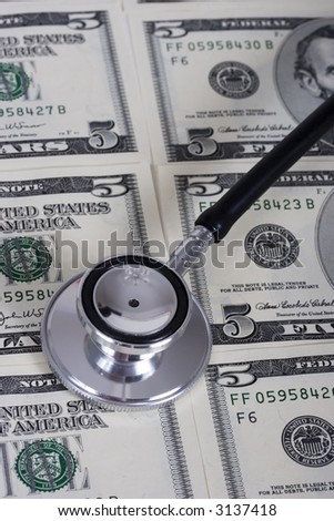 Stethoscope on money background of five dollar bills