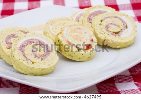 Party food on a white square plate with a red checked tablecloth