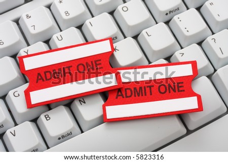 Two red and white admit one tickets on a computer keyboard