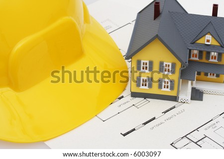 two story house with blueprints and hardhat