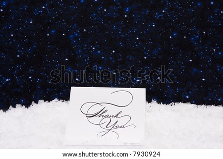 Thank you card sitting on snow with a night background