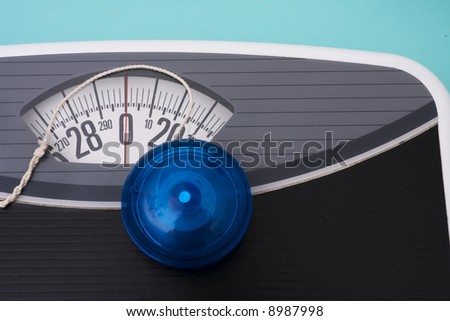 Blue yo-yo sitting on scales on blue background