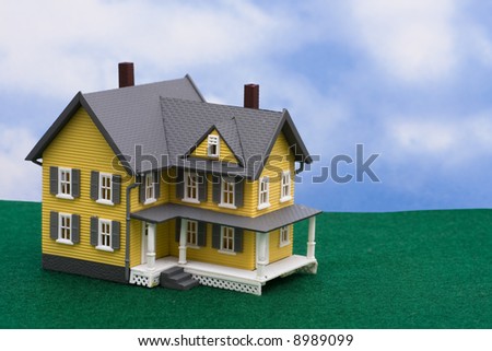 Yellow house on grass with sky background with copy space