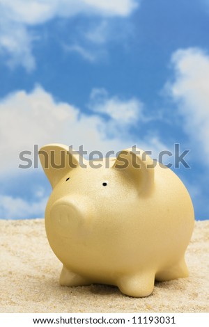 Coin bank on sand – savings for vacation or retirement