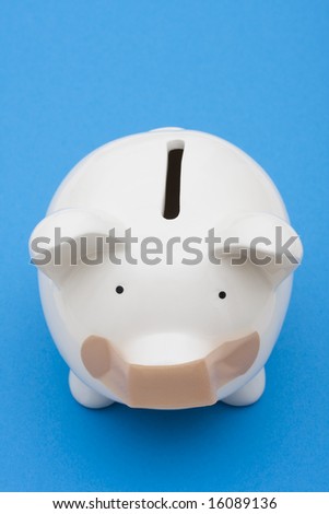 Piggy bank with adhesive bandage on mouth on blue background, investment trouble