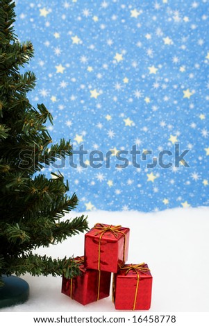 Three red Christmas presents under tree on snow with star background, Christmas presents