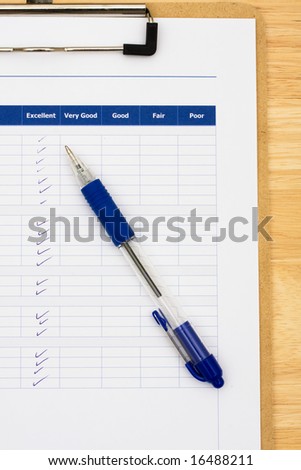 Survey attached to clipboard sitting on table with blue pen, excellent customer service