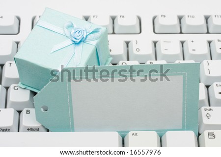 Present sitting on computer keyboard with blank gift tag, gift chopping online