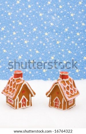 Two gingerbread houses on snow with star background, gingerbread house