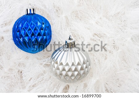 Blue and silver glass ball ornaments on white garland background, Christmas background