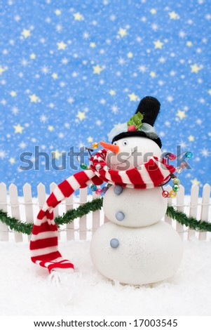Snowman and white picket fence with green garland and red bow, merry Christmas