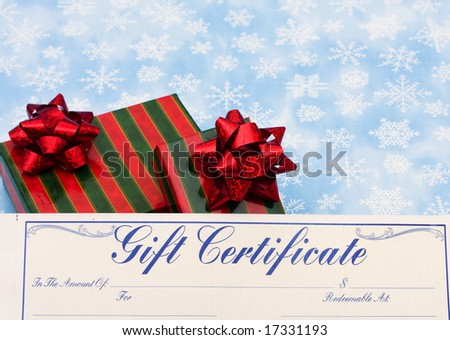 Two red and green striped wrapped presents with gift certificate on snowflake background, Christmas presents