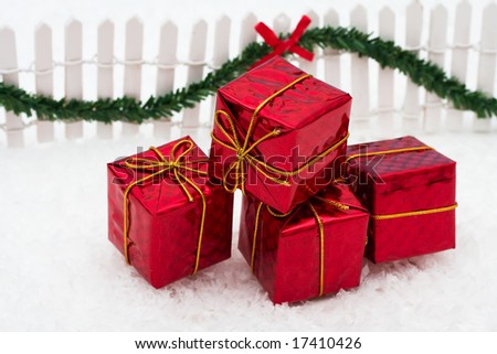 Christmas presents and white picket fence with green garland and red bow, merry Christmas