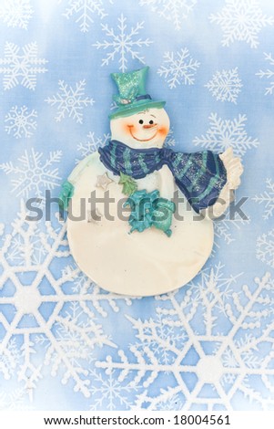 Blue background with close up of snowflake making a border with snowman, snowflake border