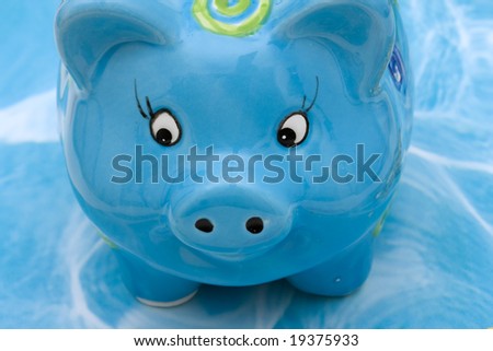 Blue piggy bank on blue background with copy space, savings