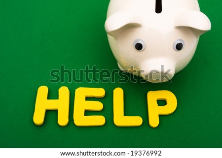 Piggy bank and the word help on green background, financial help