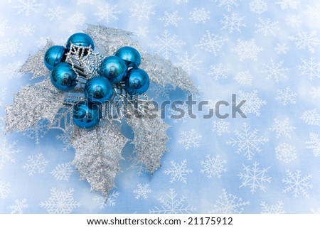 Silver leaves and blue berries on snowflake background, Christmas decoration