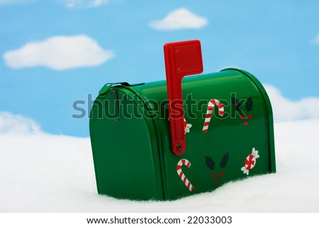 Green mailbox with candy canes and holly leaves and berries with the flag up sitting on snow with a snowflake background, mailbox