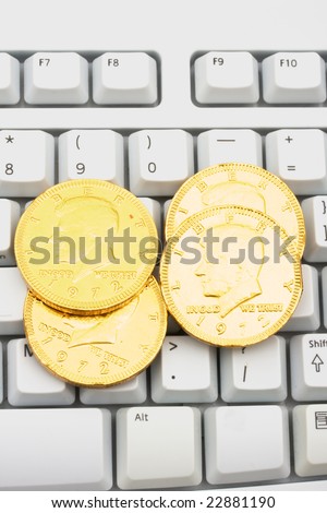 Computer keyboard with coins on it, making money online