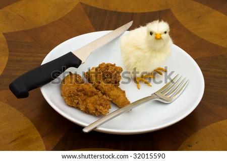 A yellow baby chicken sitting on plate with a fork and knife on a table background, please don?t eat me