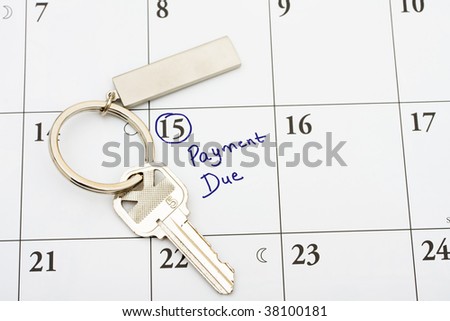 A house key on a calendar background, paying your mortgage on time