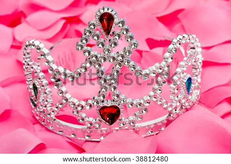 A princess tiara sitting on a pink flower petal background, princess tiara