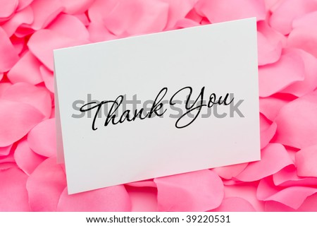 A thank you card sitting on a pink flower petal background, thank you with love