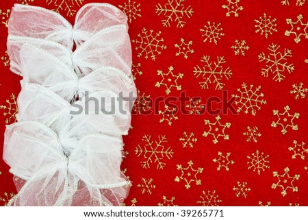 Silver bows making a border on a red snowflake background, Christmas bow border