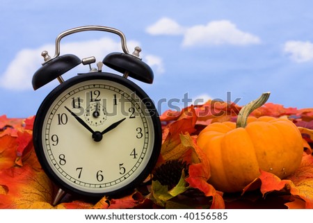 Fall colored leaves with a black clock on a sky background, Fall Leaves