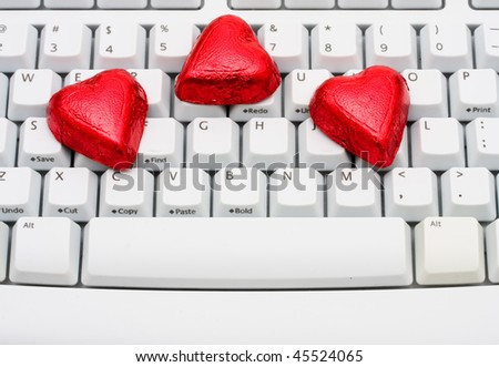 Red foiled chocolate hearts on a computer keyboard, online dating