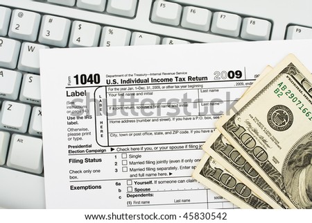 Tax papers sitting on a computer keyboard, File your tax return online