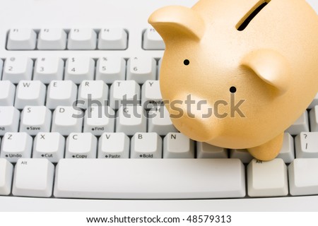 A piggy bank sitting on a computer keyboard, online banking