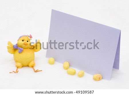 A baby chick with Easter eggs and a card on a white background, Easter message